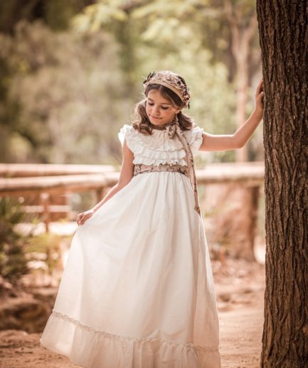 Niña llevando un vestido de comunión de manga corta.