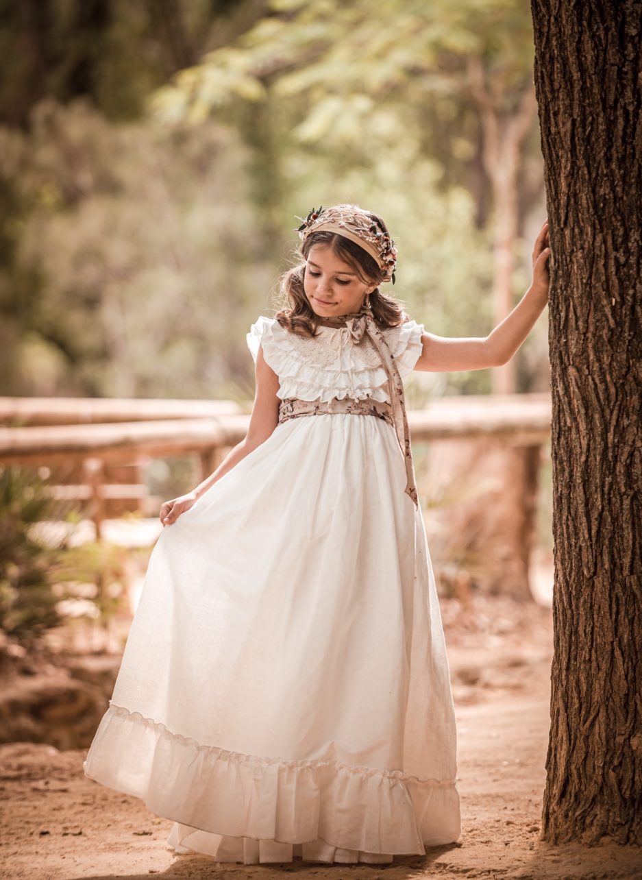 Niña llevando un vestido de comunión de manga corta.