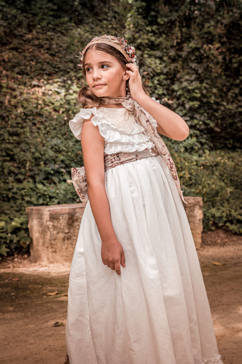 Niña posando con su vestido de novia.