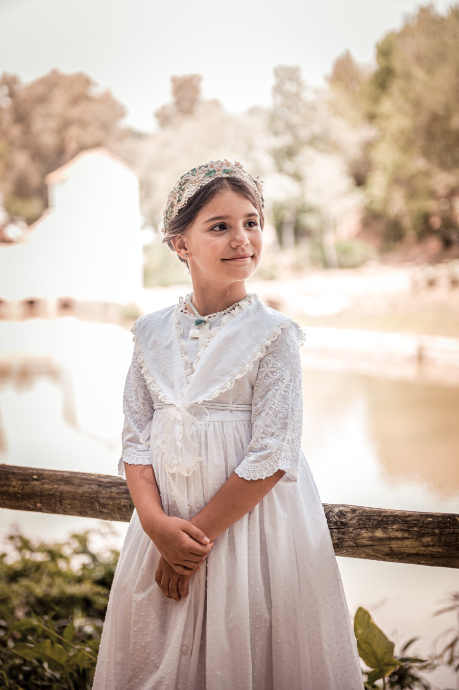 Niña luce el vestido de solapa con un pequeño recogido y una corona.