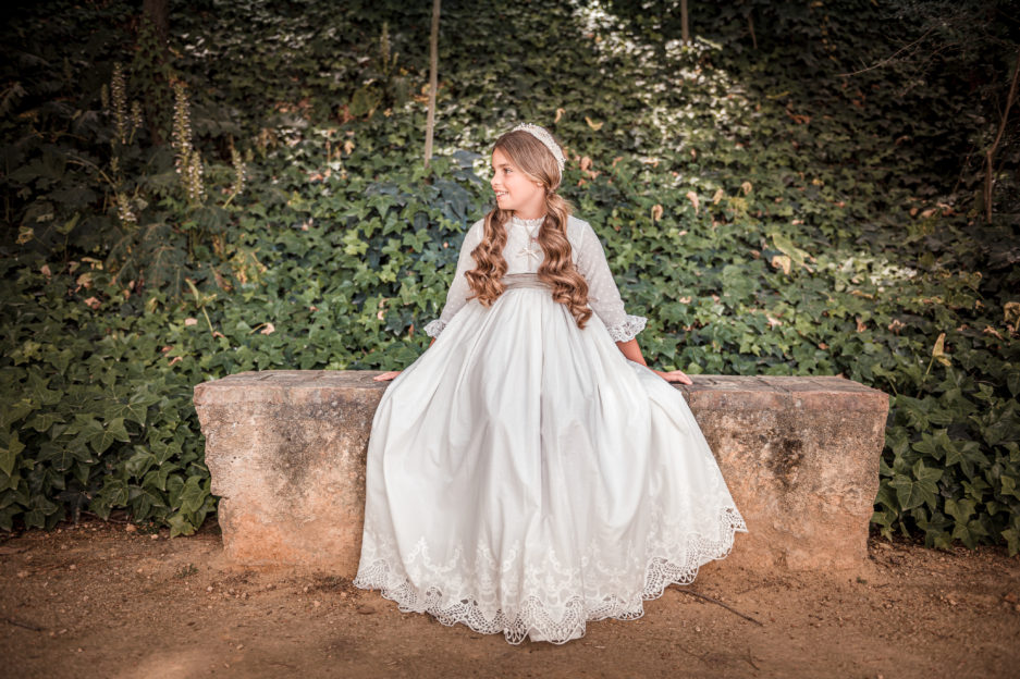 Niña luce un vestido con bordados y fajín en color tierra.