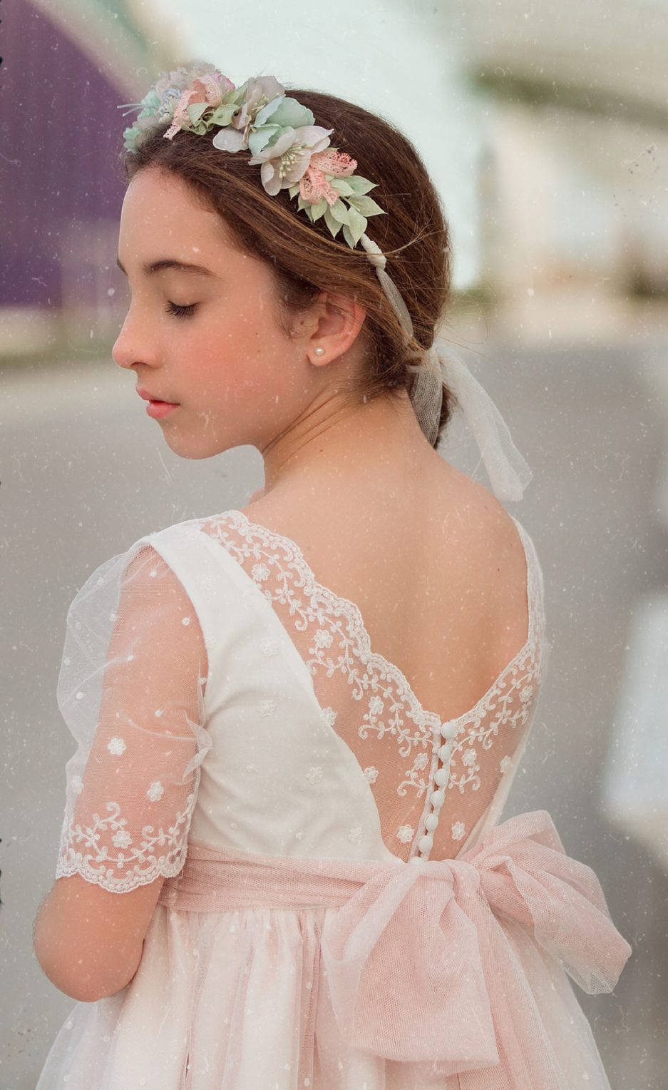 Una pequeña joven presumiendo de su pequeño traje de comunión.