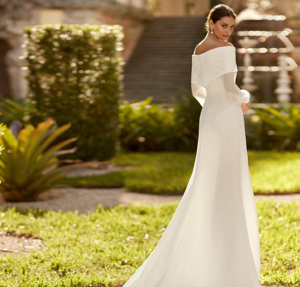 Chica luciendo un vestido de novia clásico en forma de barco.