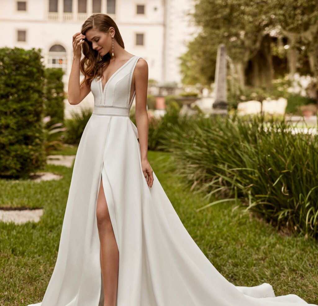 Chica fotografiada con un vestido de novia con una abertura delantera.