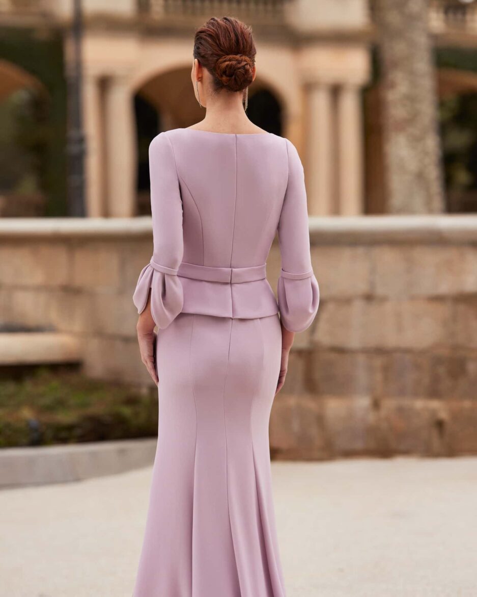 Chica posando de espaldas con un vestido lila.