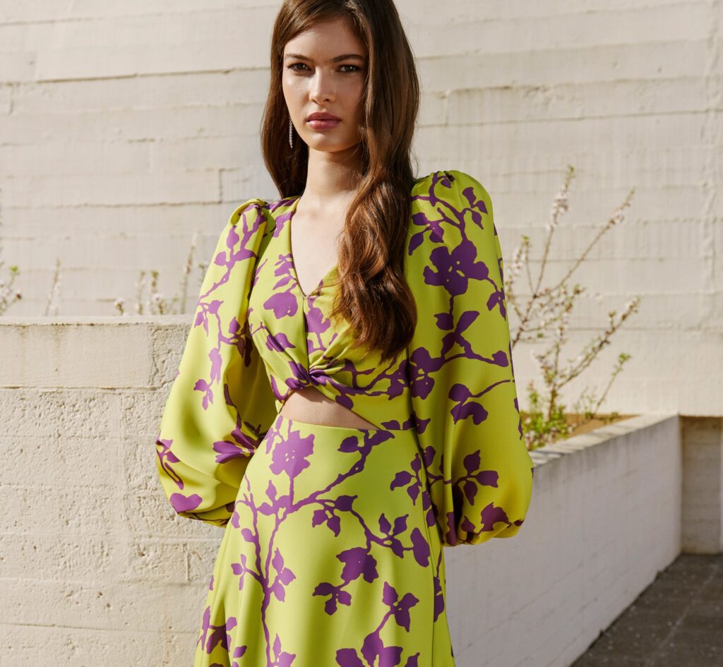 Chica joven posa con un vestido de estampado floral y de mangas abullonadas.