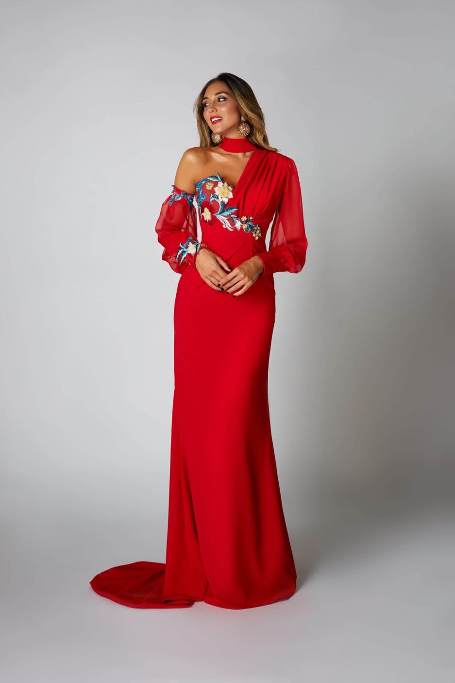 Chica posando con un vestido rojo asimétrico.
